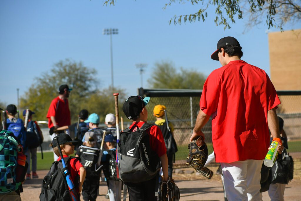 Baseball players gather near the dugout, ready for practice or a game.