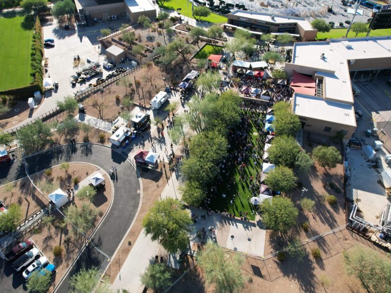 Aerial view of a park with pathways, trees, and people walking.
