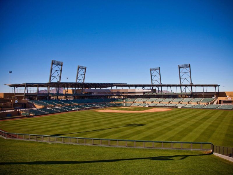 Empty baseball stadium with clear blue sky.