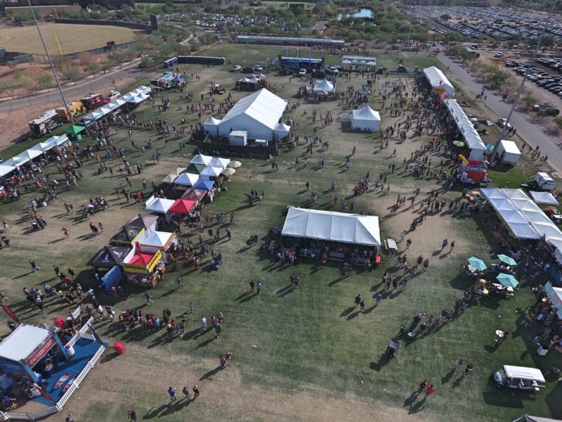 Aerial view of an outdoor event with tents and people.