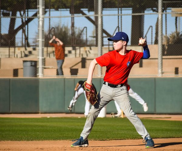 Young baseball player pitching during a game on a sunny day.