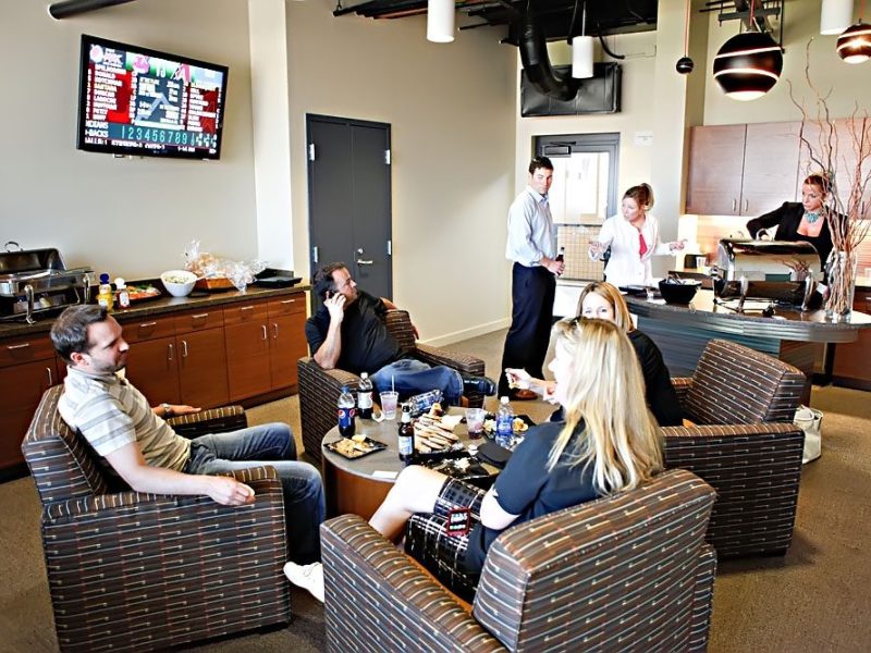 Casual meeting in a cozy office lounge with snacks and multiple people engaged.